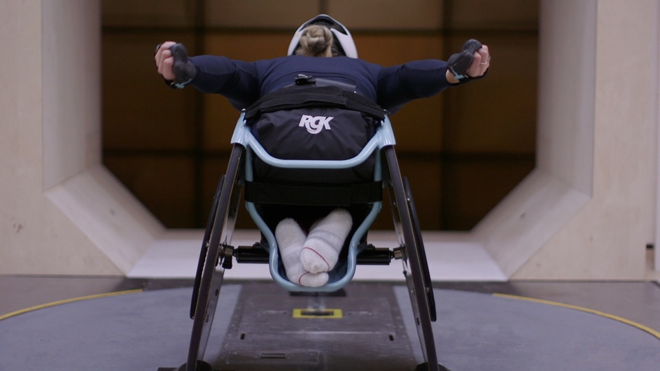 A wheelchair racing athlete going through racing poses at a wind tunnel in Manchester.